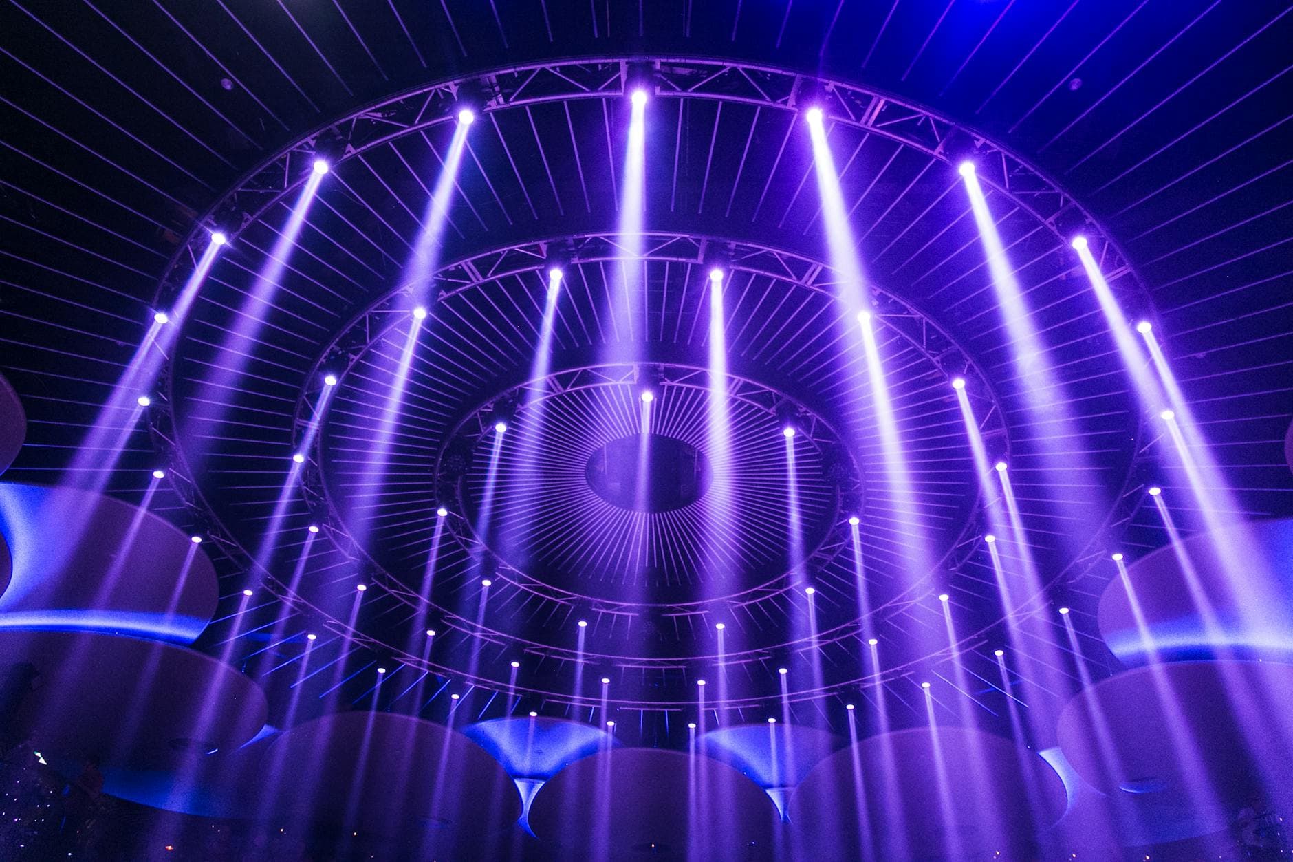 Dramatic blue and purple beam fan across an empty stage