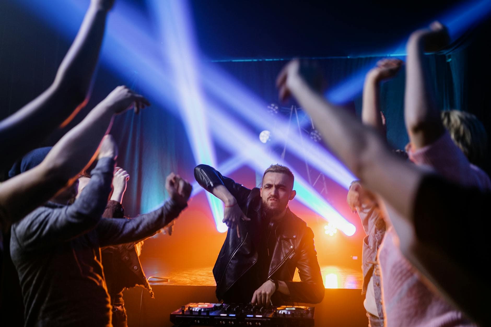 DJ booth with raised hands in crowd