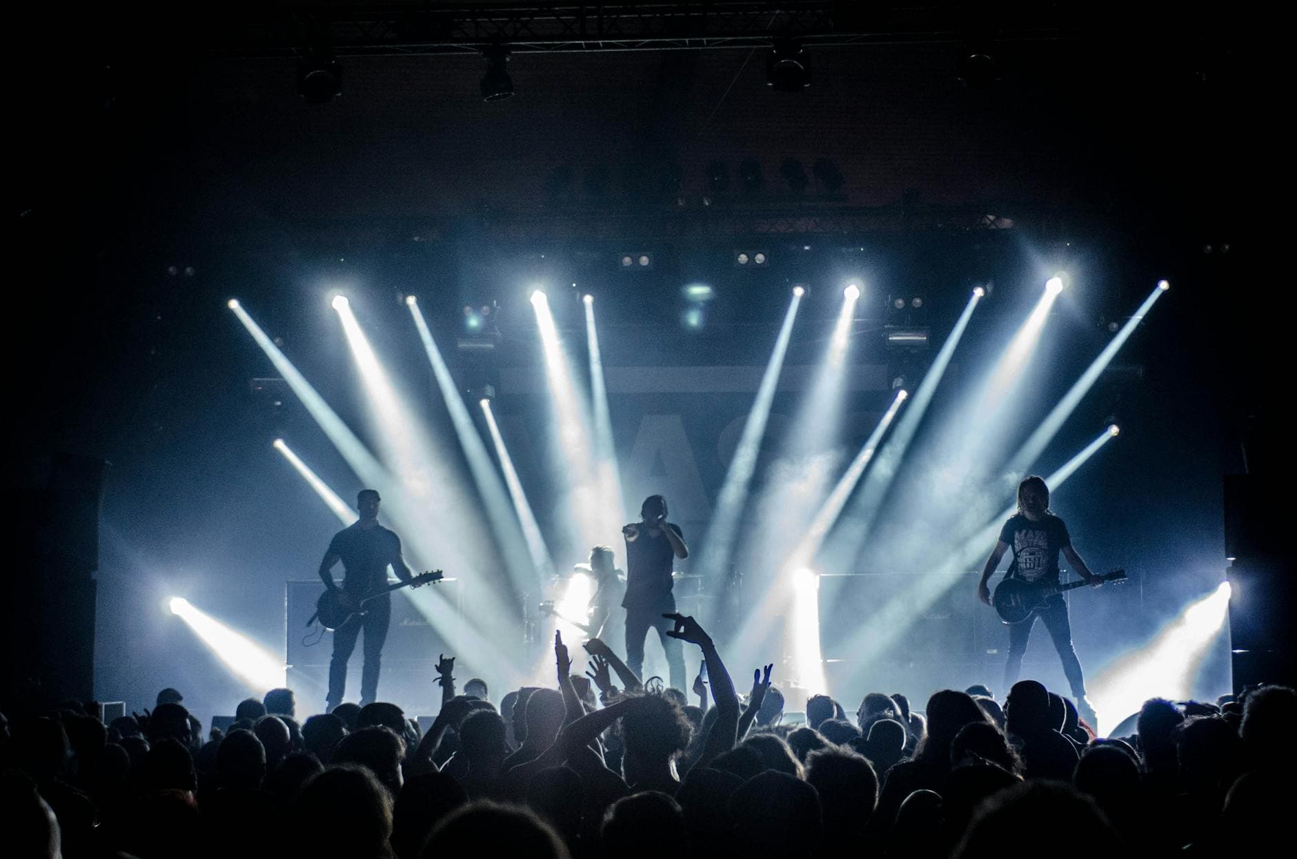 Silhouetted band onstage with parallel beam lighting